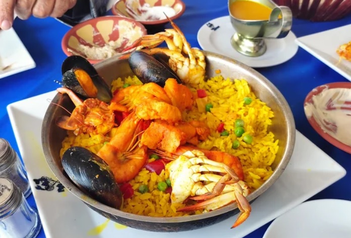 Meeresfrüchtereis mit Garnelen, Muscheln und Krabbe in einer Metallpfanne serviert
