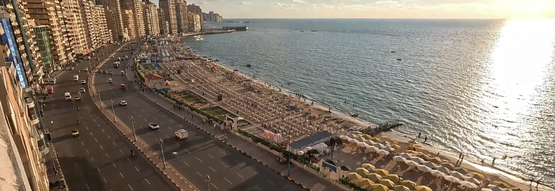 Luftaufnahme der Stanley Corniche mit Strand und Hochhäusern bei Sonnenuntergang