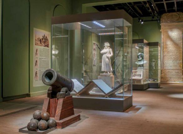 Museumsausstellung mit einer alten Kanone, Kanonenkugeln und historischen Exponaten