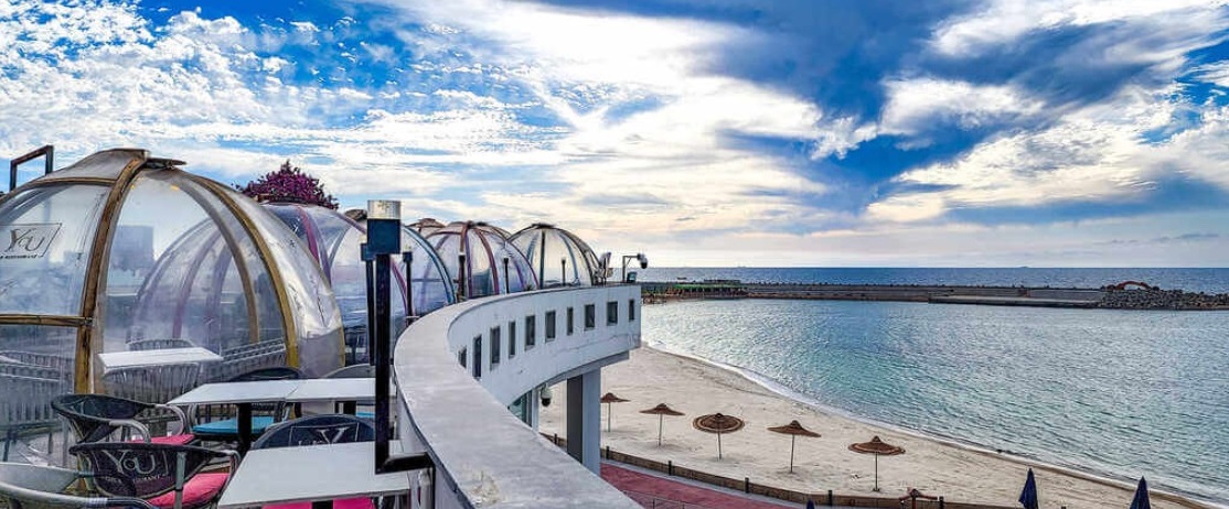 Caffè moderno con cupole di vetro trasparente che si affaccia sul mare ad Alessandria.