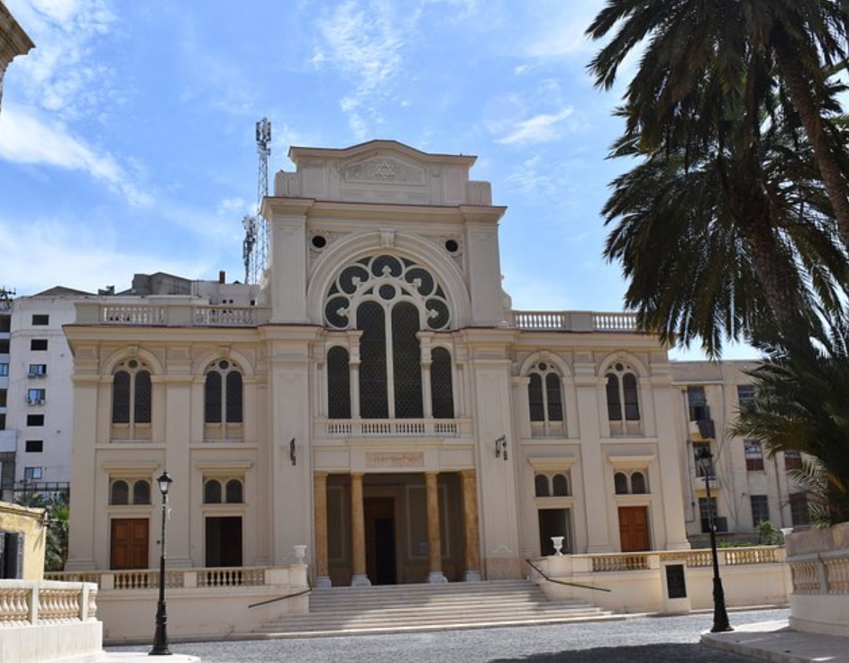 Exterior de la Sinagoga Eliyahu Hanavi restaurada en Alejandría, con palmeras.