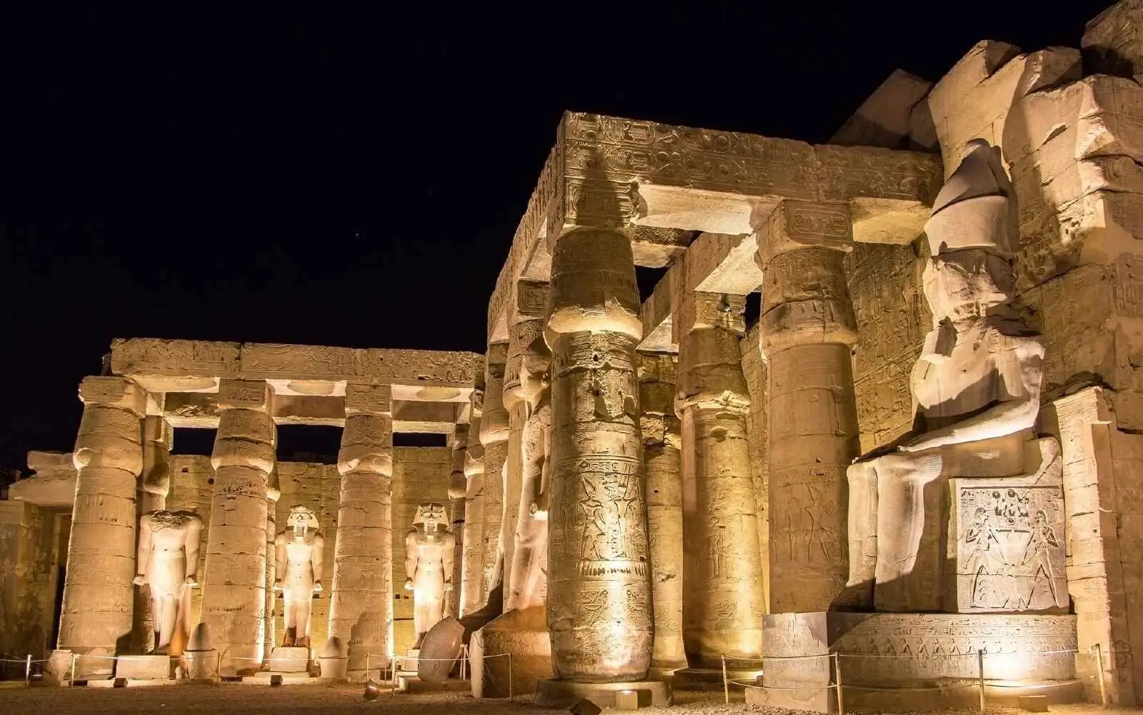 Nilkreuzfahrt: Beleuchtete Ramses-Statuen und Säulen im Luxor-Tempel bei einer Al Kahila Tour.