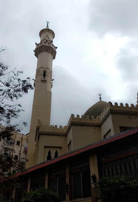 Beige minaret and dome of the historic Mustafa Kamel Mosque in Alexandria.