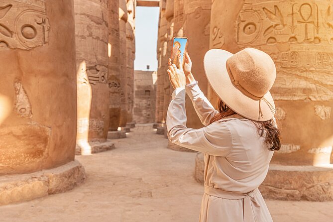 Viajera tomando fotografías entre las columnas del Templo de Karnak.