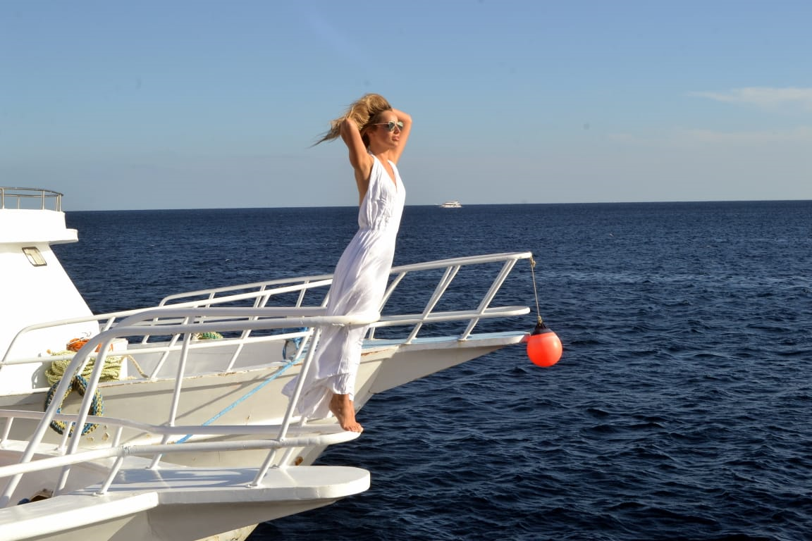 Mujer disfrutando de las vistas del Mar Rojo desde la proa de un barco.