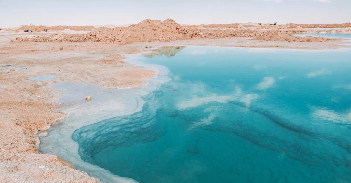 Vista del lago salado con aguas azules y orillas blancas en el Oasis de Siwa.