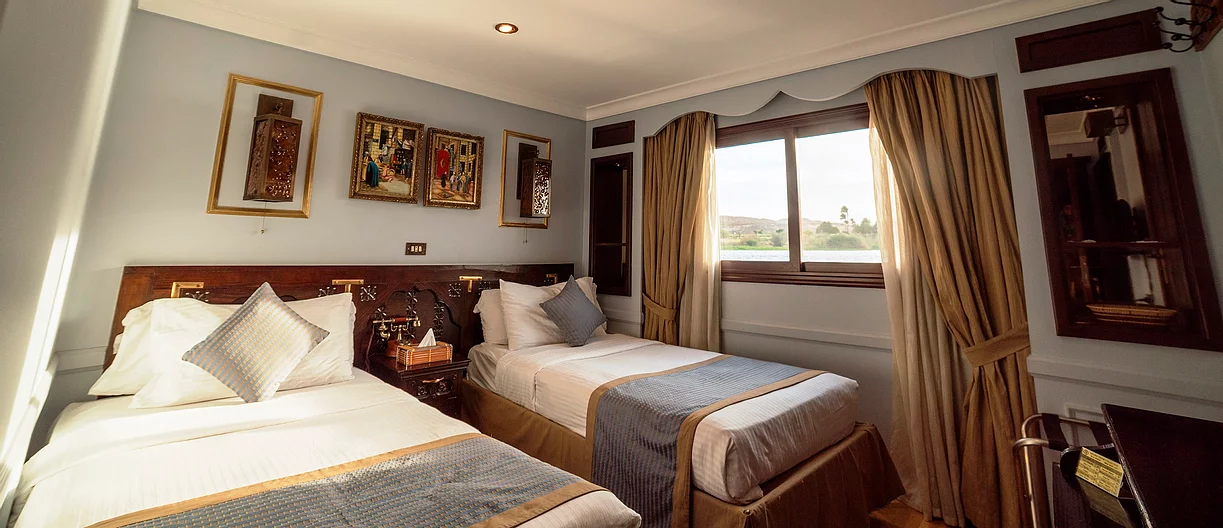 Habitación elegante con vistas al río Nilo en un crucero Dahabiya.