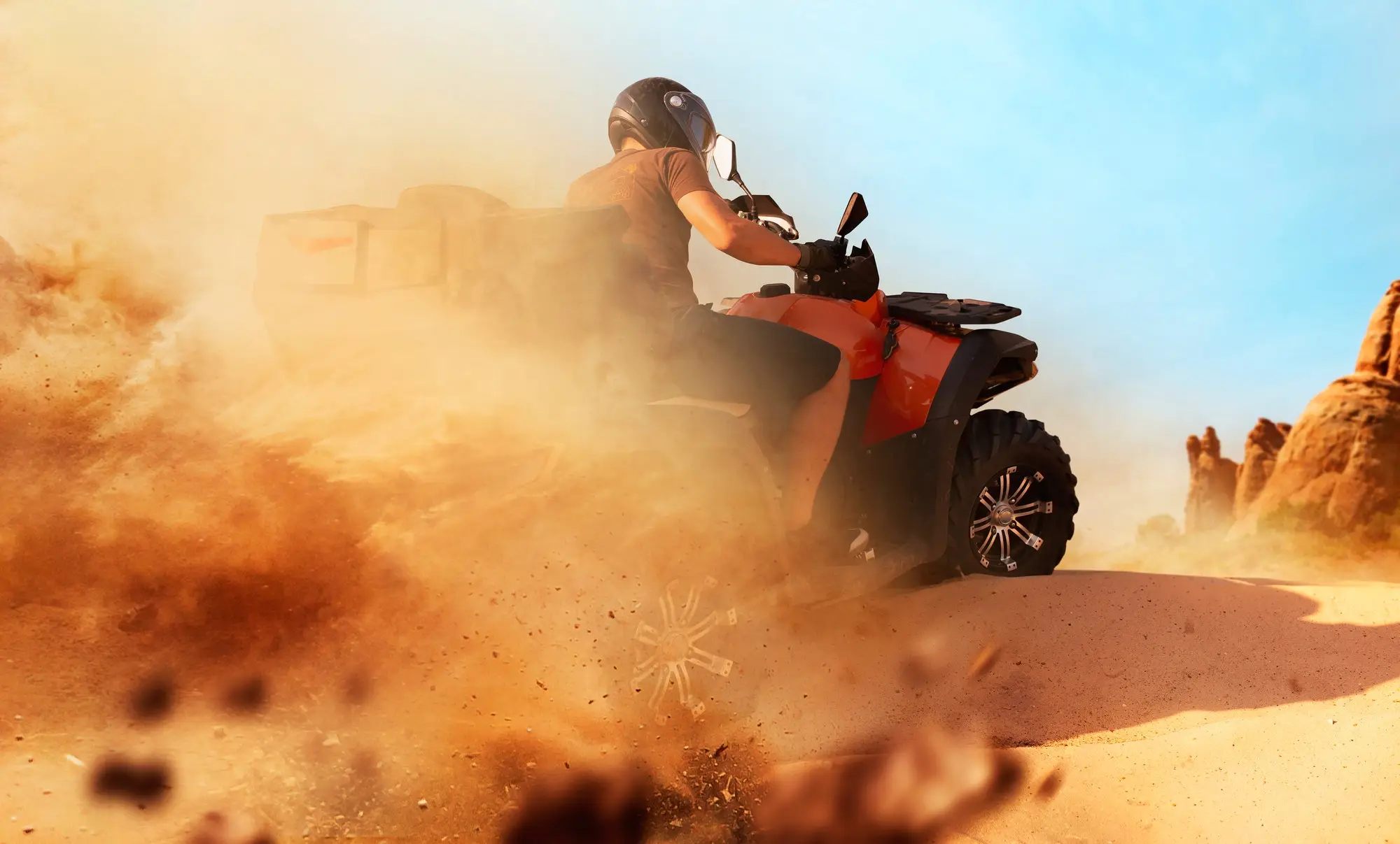 Ein Quad-Fahrer wirbelt Sand auf einer Wüstendüne auf
