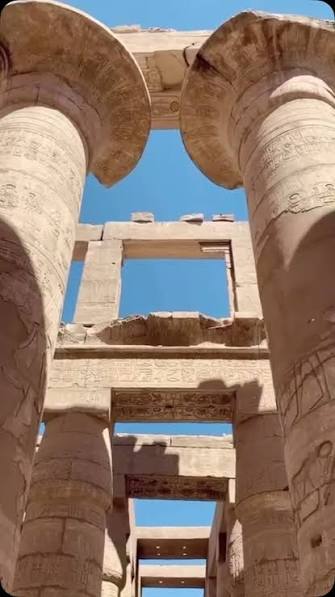 Stone entrance of Kalabsha Temple framed by ancient walls under a clear blue sky in Aswan.