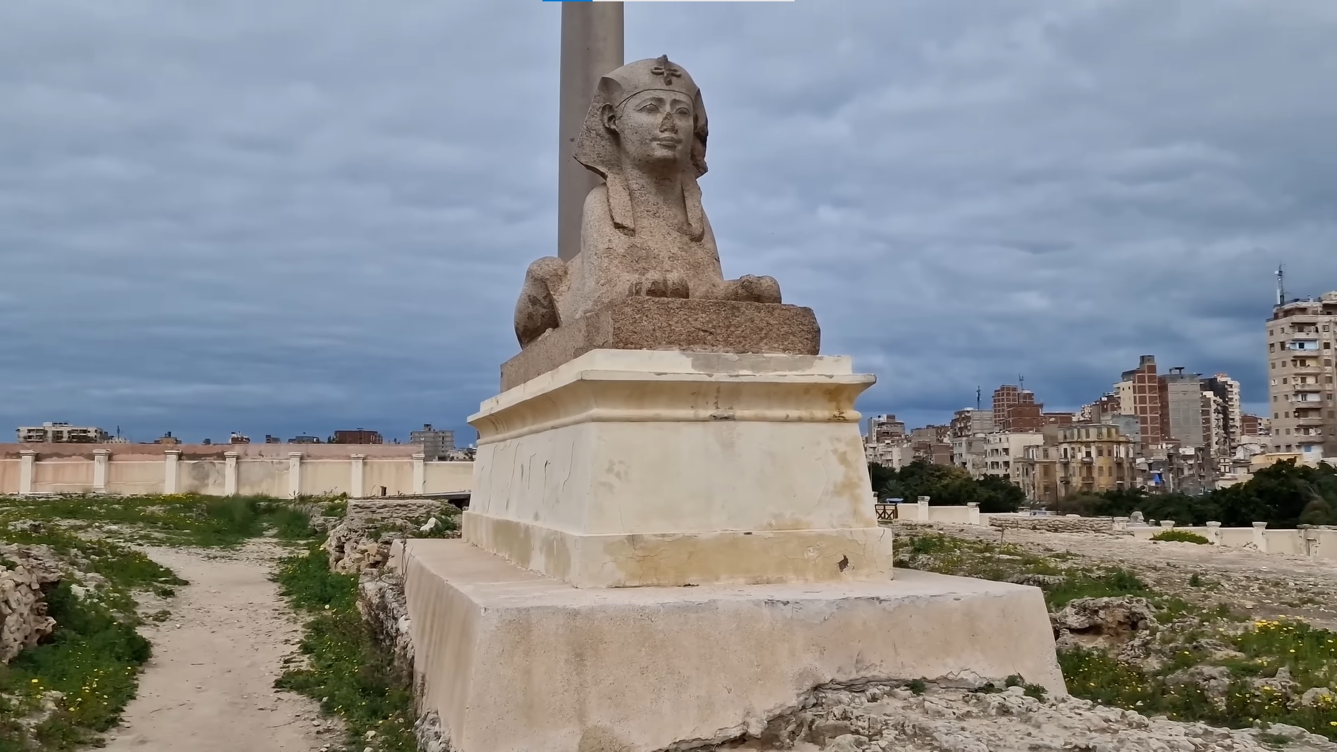 Granite sphinx and Pompey's Pillar with Alexandria's city skyline in the background