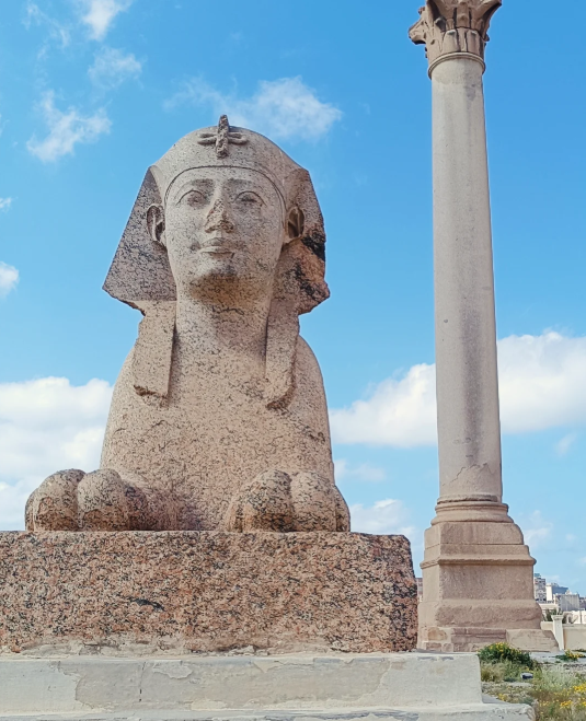 Nahaufnahme einer Granit-Sphinx neben der Pompeiussäule vor klarem blauem Himmel