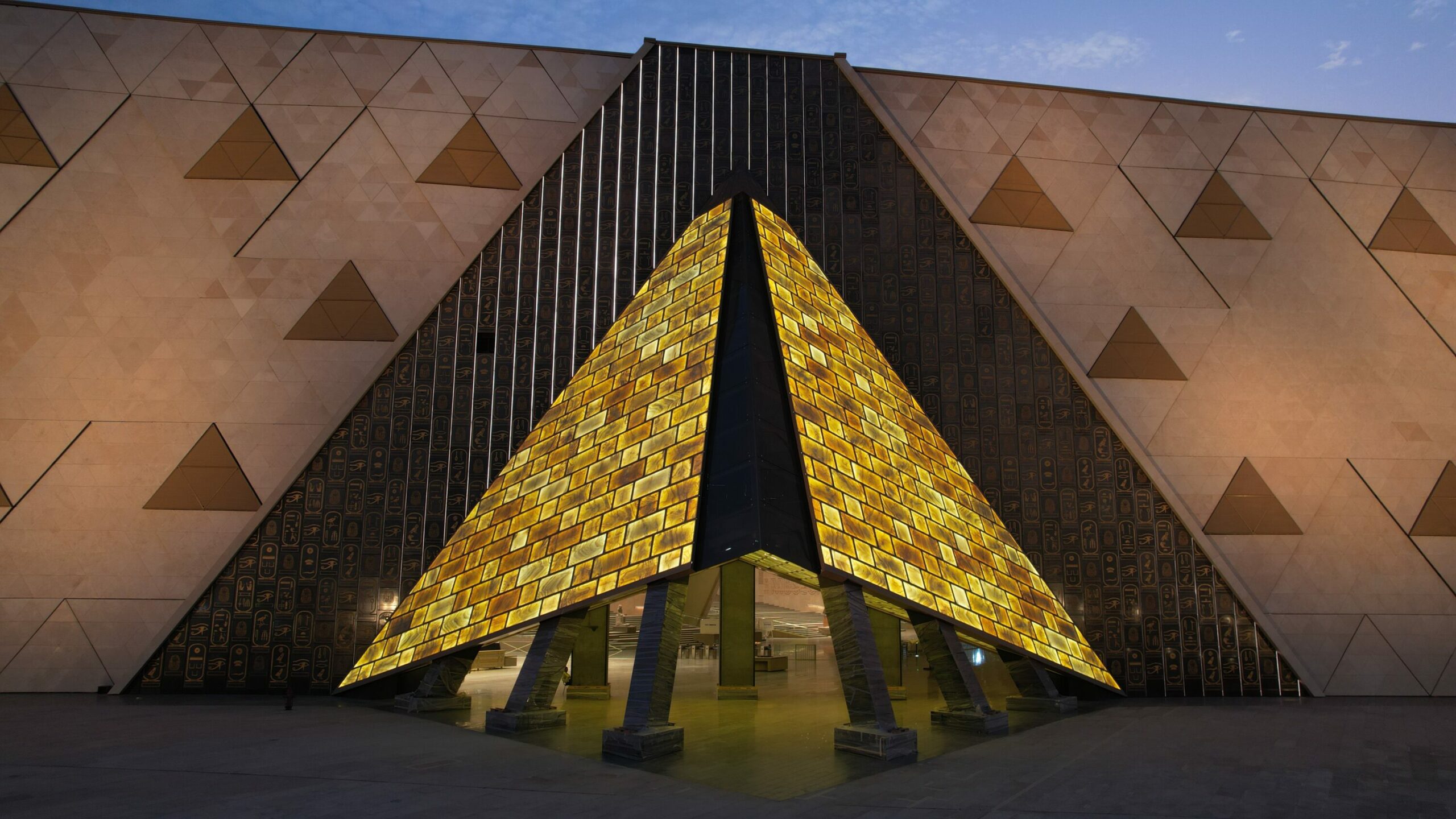 Grand Egyptian Museum entrance with its illuminated golden pyramid structure