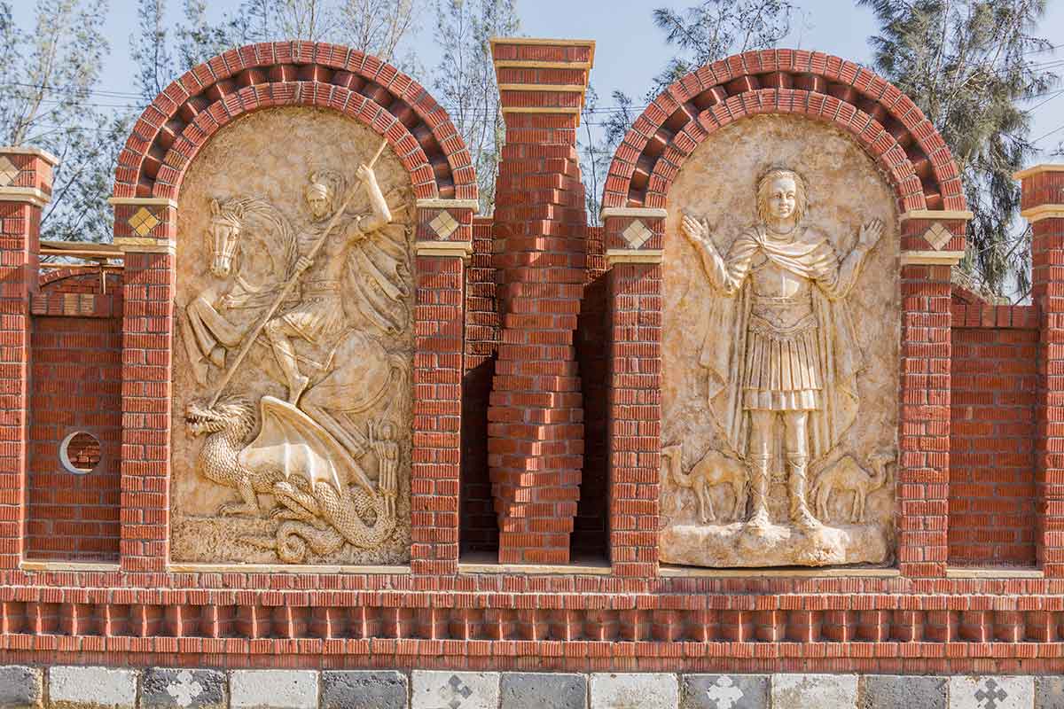 Religious reliefs depicting Christian figures on a brick wall at Dar El Sourian Monastery